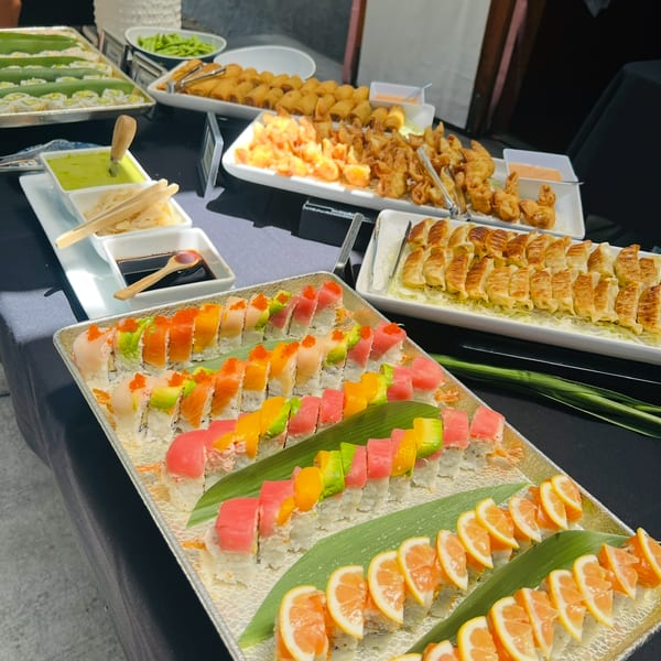 Catering buffet with specialty rolls, gyoza, spring rolls, and dumplings