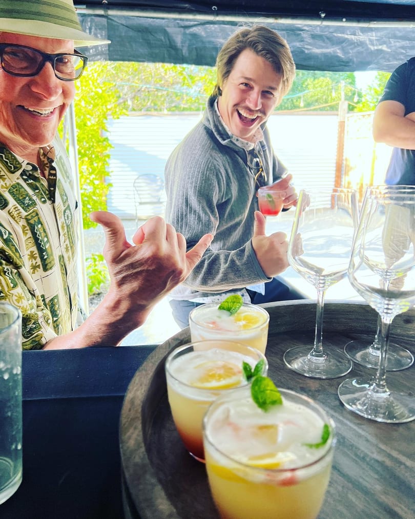 Guests toasting with fresh cocktails on the bamboo-shaded patio
