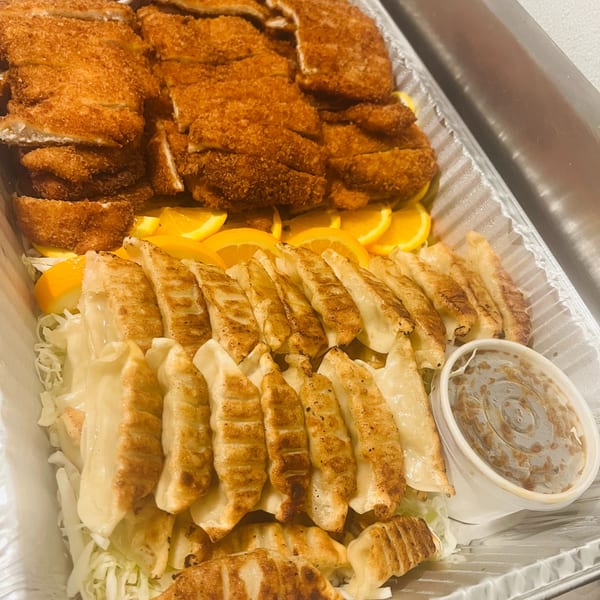 Catering tray of chicken katsu and pan-seared gyoza with dipping sauces