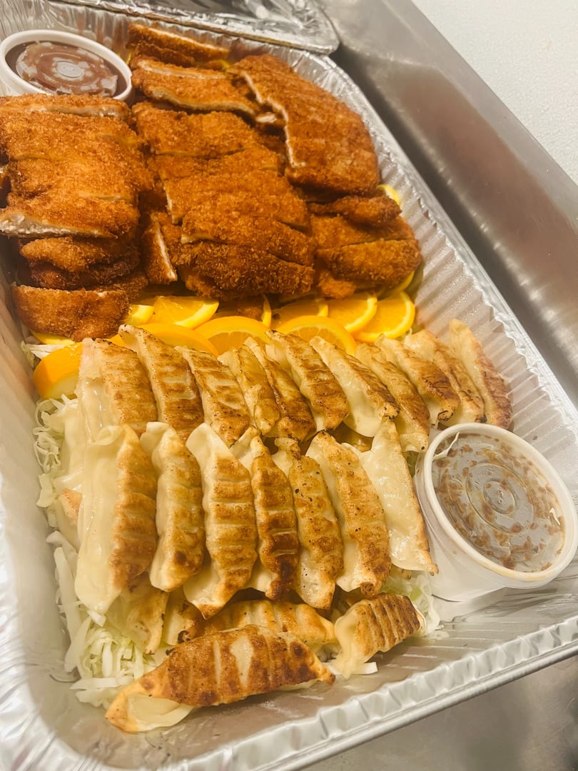 Catering tray of chicken katsu and pan-seared gyoza with dipping sauces
